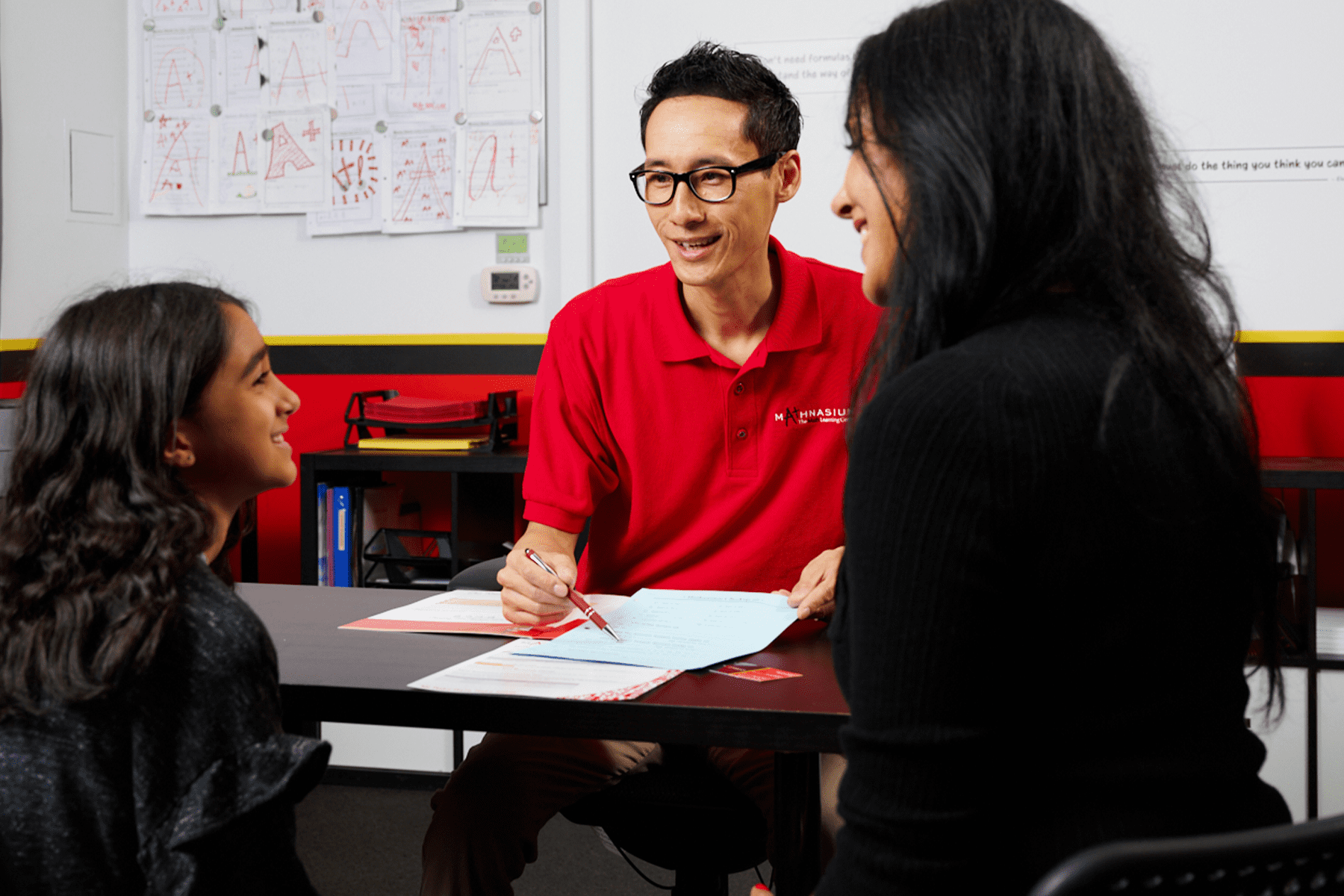 Math tutor discussing personalized learning plan with a student and their parent