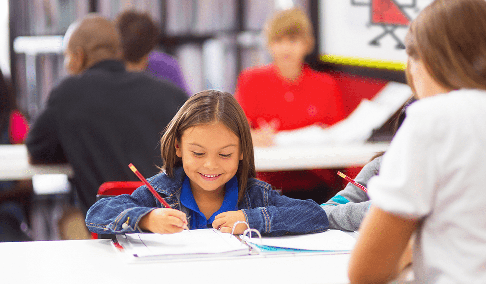 A young girl writing answers to a math problem.