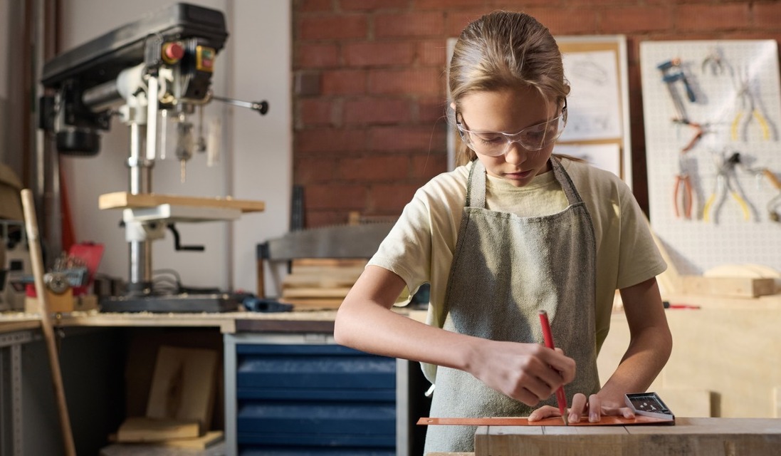 Student measuring a piece of wood with a ruler