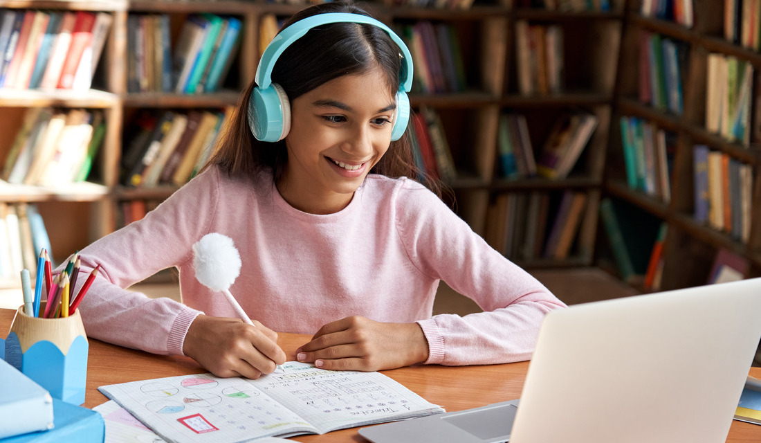 A middle school girl receiving online math tutoring in a school library