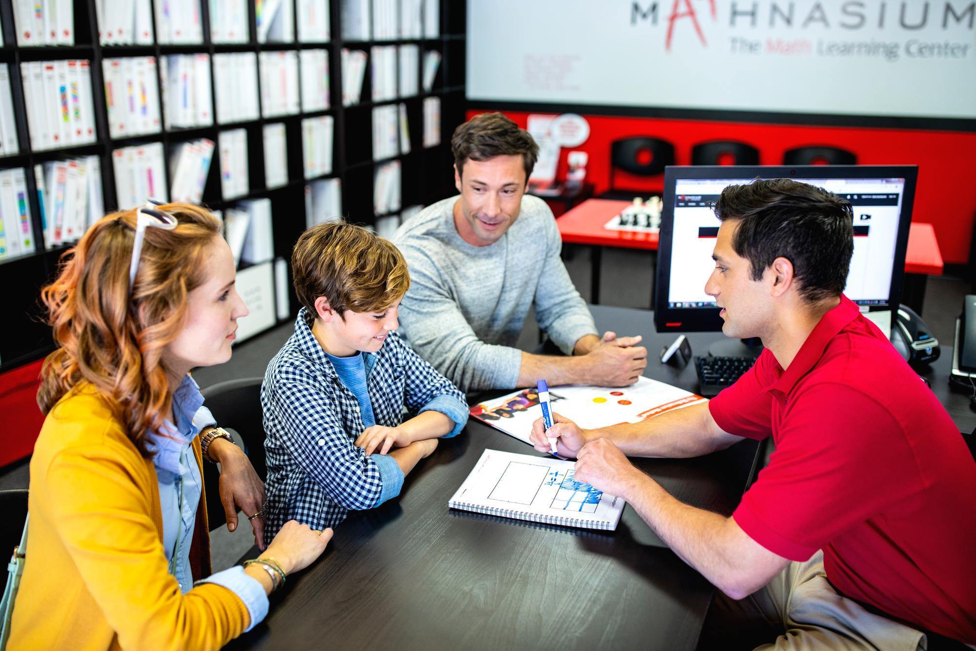 Mathnasium tutor explains a personalized learning plan to parents and their son.