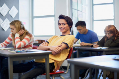 A classroom scene featuring students at desks, participating in lessons and collaborating on assignments.