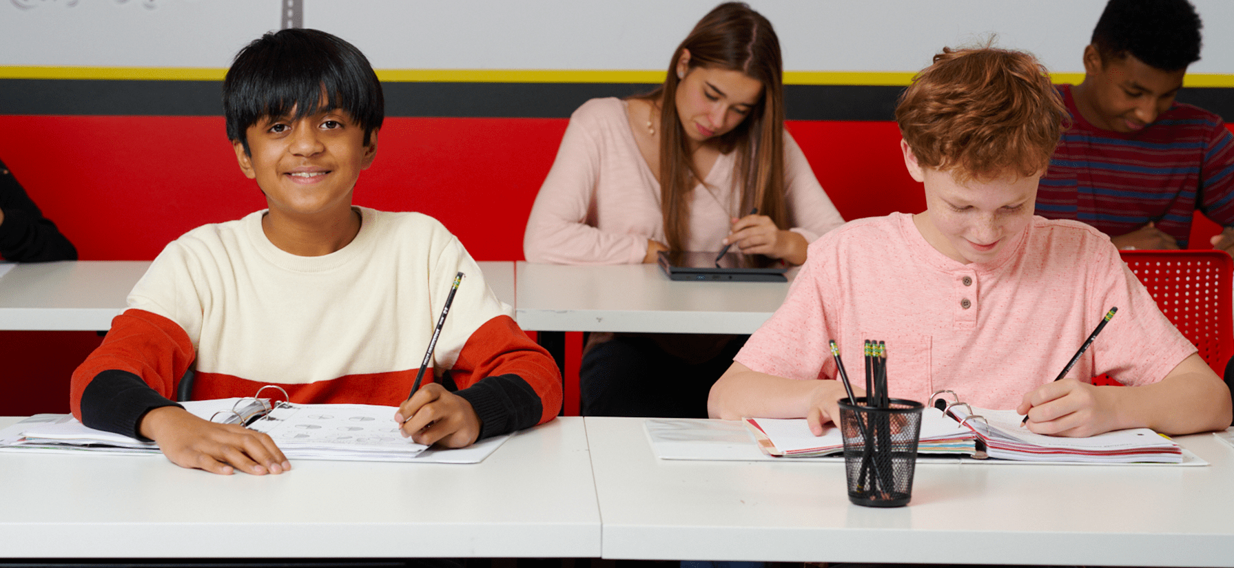 Students sitting at a desk, completing maths practise problems.
